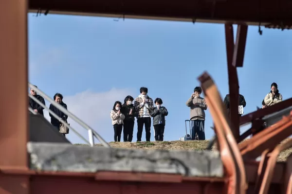 La gente reza durante un momento de silencio que conmemora a las víctimas del terremoto de 2011, el tsunami y el desastre nuclear.